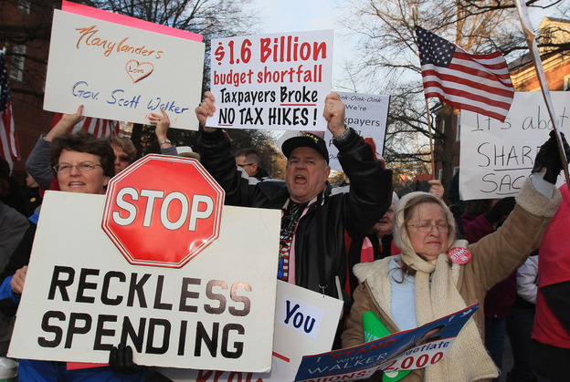 Tea Party supporters hold signs across from a rally held by the American Federation of State, County and Municipal Employees in front of the Maryland State Capitol building in Annapolis on March 14.