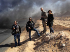 Ras Lanuf, March 11: Lynsey Addario and Tyler Hicks of The New York Times (center left and right) stand on the side of a road in Libya with Yuri Kosyrev of Time magazine and freelancer Nicki Sobecki. Four days later, Addario and Hicks were taken captive along with Times journalists Anthony Shadid and Stephen Farrell. Ras Lanuf, March 11: Lynsey Addario and Tyler Hicks of The New York Times (center left and right) stand on the side of a road in Libya with Yuri Kosyrev of Time magazine and freelancer Nicki Sobecki. Four days later, Addario and Hicks were taken captive along with Times journalists Anthony Shadid and Stephen Farrell.