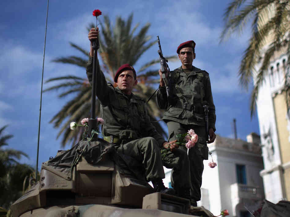 A Tunisian soldier arranges flowers on his tank on Jan. 21 in Tunis. A Tunisian soldier arranges flowers on his tank on Jan. 21 in Tunis.