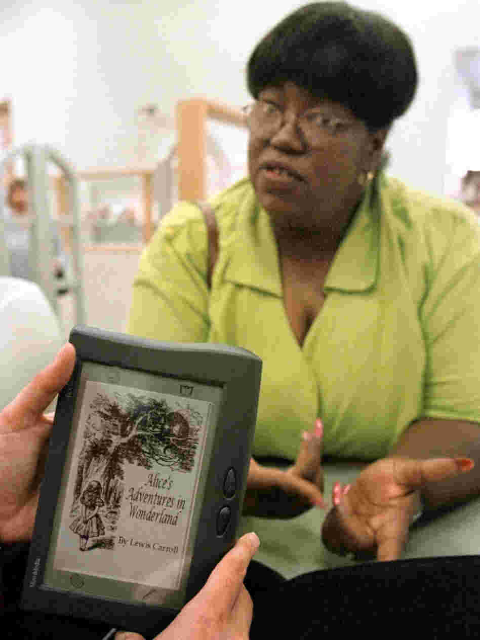 Chicago Public Library patron  Anna Sykes talks with a librarian about the book Alice's Adventures in  Wonderland, a title available on one of nine new Rocket e-books. Providing e-books is just one of many services that libraries are trying out in an attempt to stay relevant in the Kindle age.