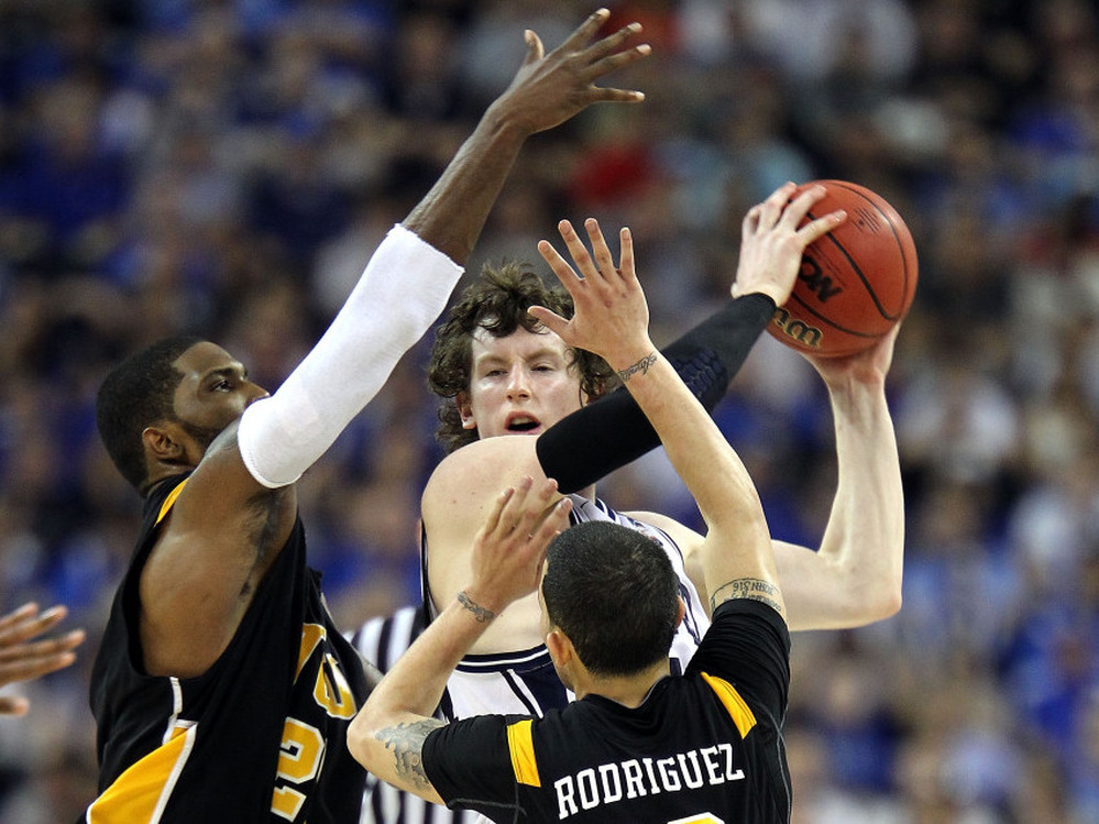 Matt Howard (center) of the Butler Bulldogs handles the ball against Jamie Skeen (left) and Joey Rodriguez of the Virginia Commonwealth Rams during the National Semifinal game of the 2011 NCAA Division I Men's Basketball Championship at Reliant Stadium on April 2 in Houston.
