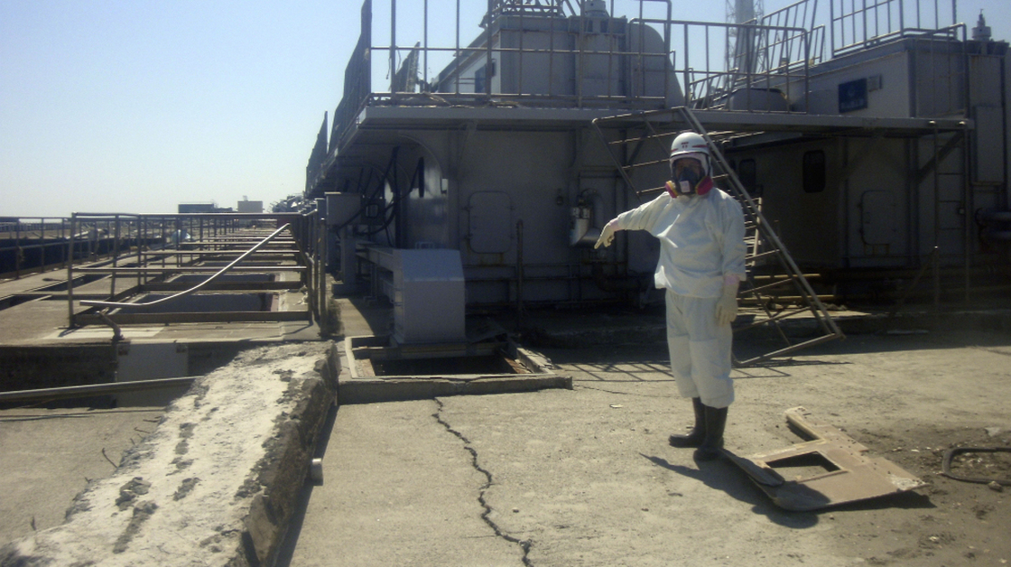 A TEPCO employee points at a crack discovered April 1 in a maintenance pit on the edge of the Fukushima Dai-ichi nuclear nuclear power plant in northeastern Japan.
