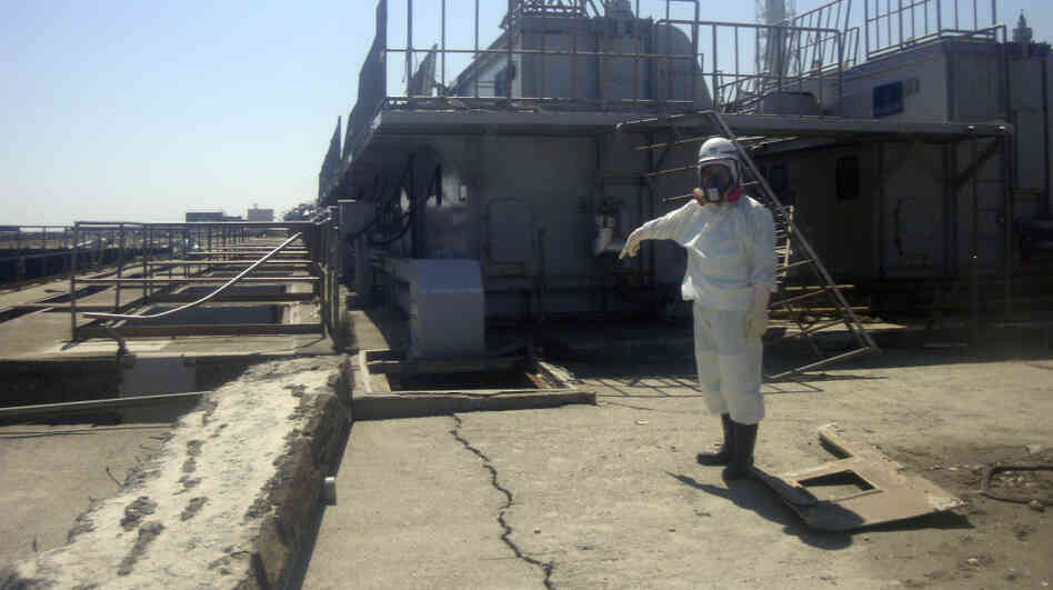 A TEPCO employee points at a crack discovered April 1 in a maintenance pit on the edge of the Fukushima Dai-ichi nuclear nuclear power plant in northeastern Japan.