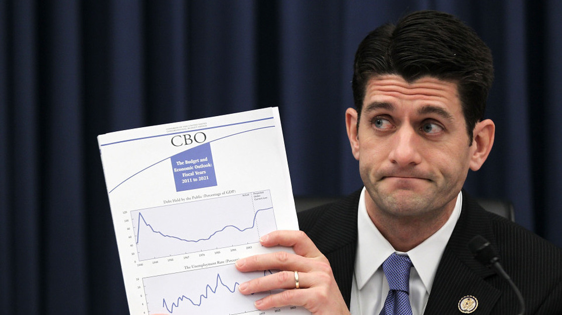 At a House Budget Committee hearing in February, Rep. Paul Ryan (R-WI) holds up a Congressional Budget Office report on the federal budget.