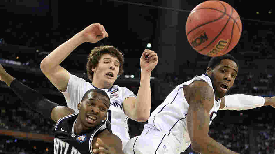 Shelvin Mack of the Butler Bulldogs fights for the ball against Tyler Olander and Alex Oriakhi of the Connecticut Huskies during the National Championship Game.