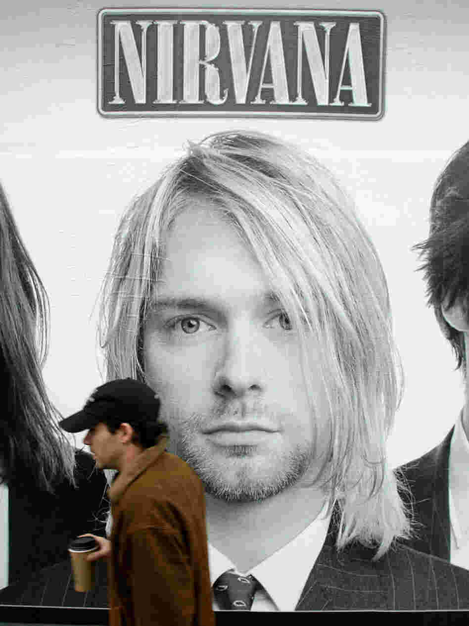 A pedestrian walks past a picture of Kurt Cobain on a mural of the cover the Nirvana box set "With the Lights Out," on Nov. 23, 2004.