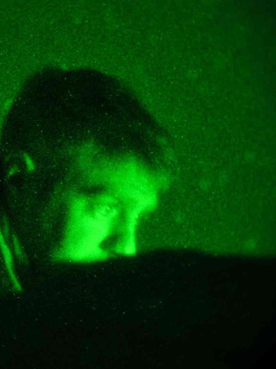 In the middle of the night, Tech. Sgt. John Oliver watches a video monitor and communicates with pilots thousands of feet overhead. In the middle of the night, Tech. Sgt. John Oliver watches a video monitor and communicates with pilots thousands of feet overhead.
