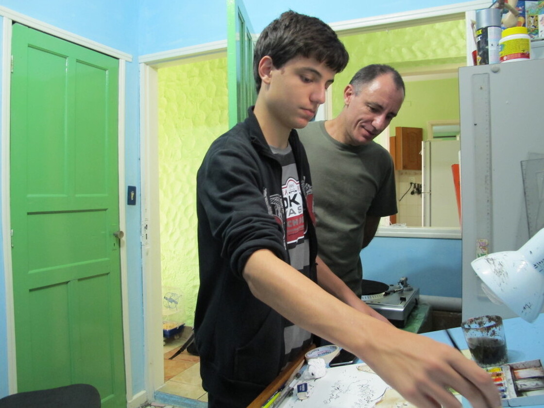 Joao Montanaro works on a cartoon in his studio with his father, Mario  Barbosa. He says his fascination with cartoons began when his dad showed him several anthologies featuring Brazil's best cartoonists when he was younger.