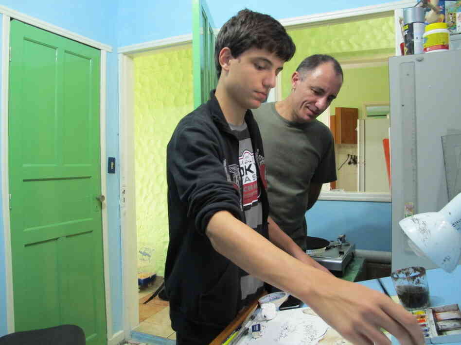Joao Montanaro works on a cartoon in his studio with his father, Mario  Barbosa. He says his fascination with cartoons began when his dad showed him several anthologies featuring Brazil's best cartoonists when he was younger.