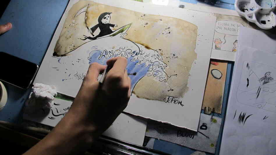 Joao Montanaro works on a cartoon illustrating the devastation the tsunami brought to Japan.