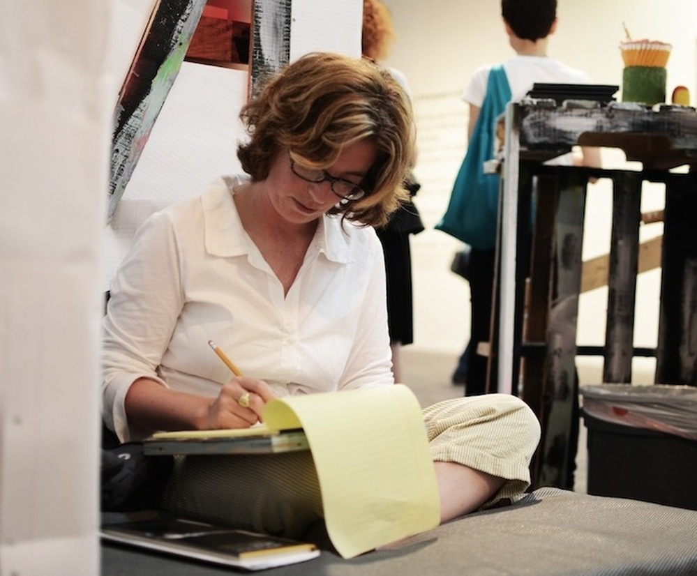 Writer Gaby Calvocoressi pens an impromptu poem at Abe's Penny Live, an O, Miami event in which visitors were invited to write poetry in response to the work of Miami photographers.