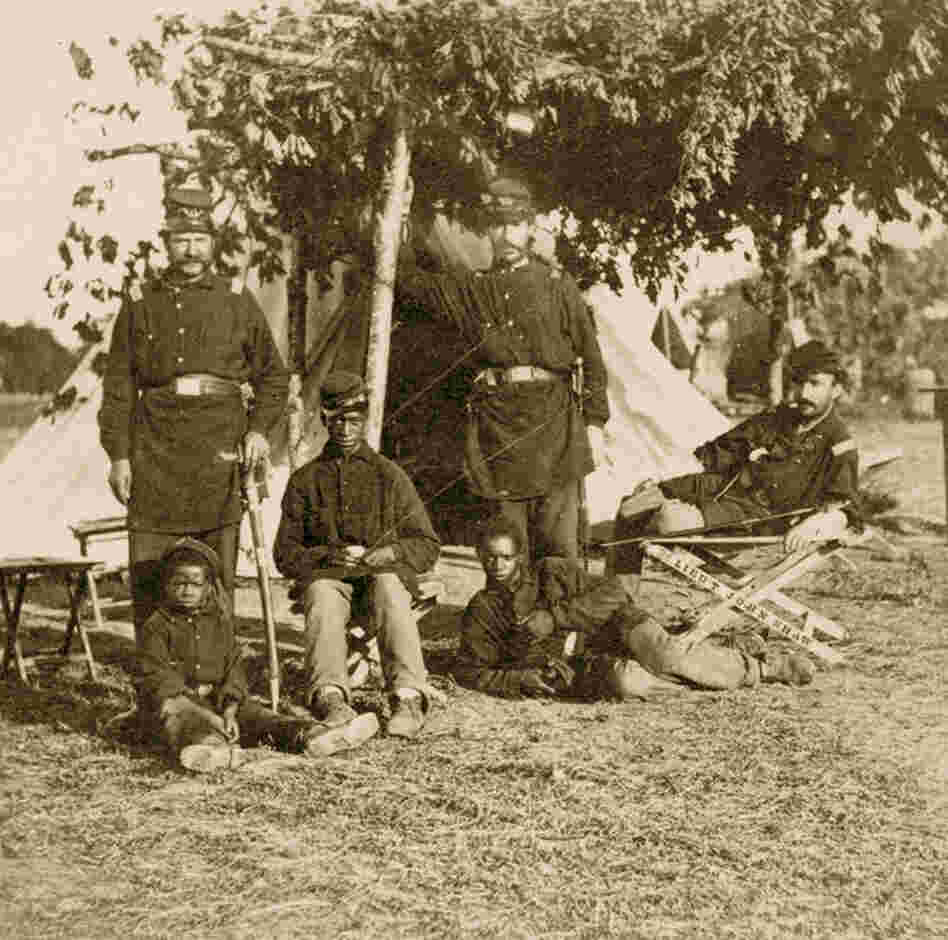 Union officers pose with escaped slave children. 