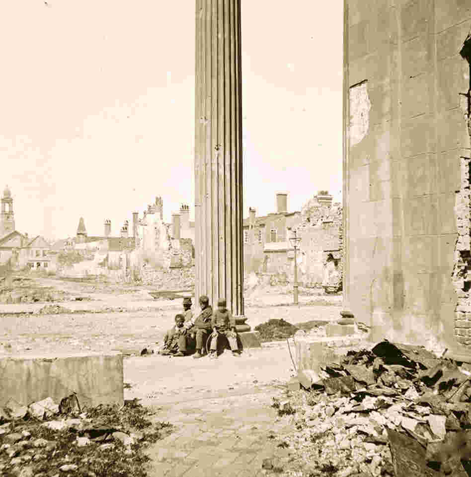 Four freed African-American children sit amid the ruins of Charleston, S.C., in 1865. 