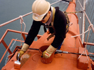 A painter touches up one of the bridge's cables. When it came time to decide the paint color for the bridge, consulting architect Irving Morrow wanted a warm hue to contrast with the cool grays, blues and greens of San Francisco Bay. A painter touches up one of the bridge's cables. When it came time to decide the paint color for the bridge, consulting architect Irving Morrow wanted a warm hue to contrast with the cool grays, blues and greens of San Francisco Bay.