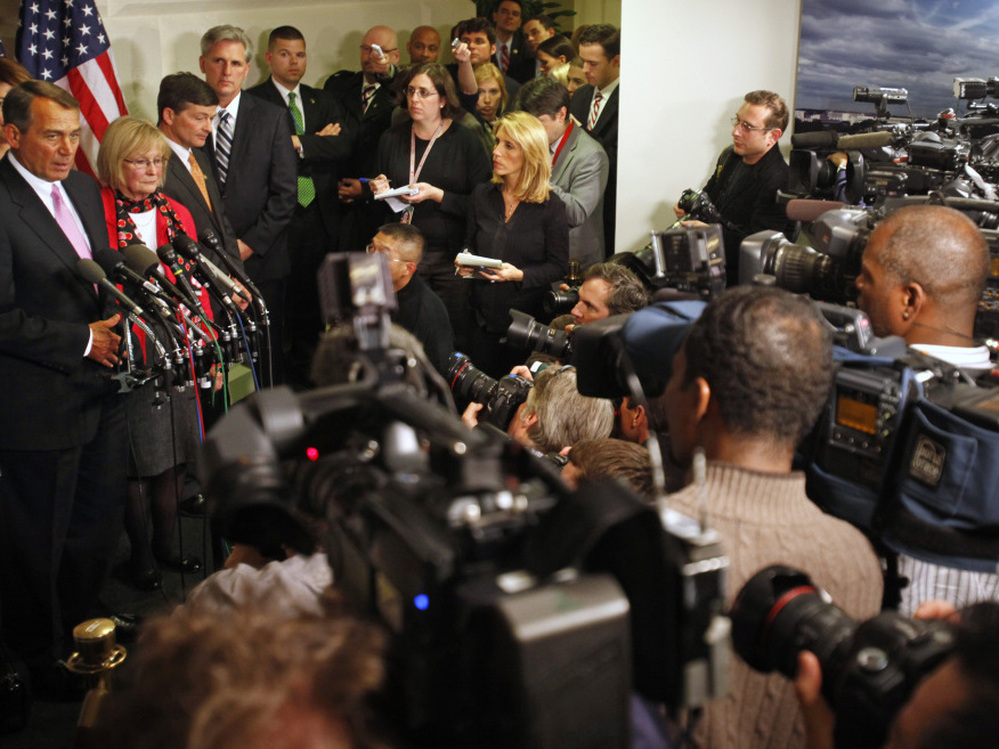 Surrounded by news media, House Speaker John Boehner announces a deal was reached, avoiding a government shutdown.