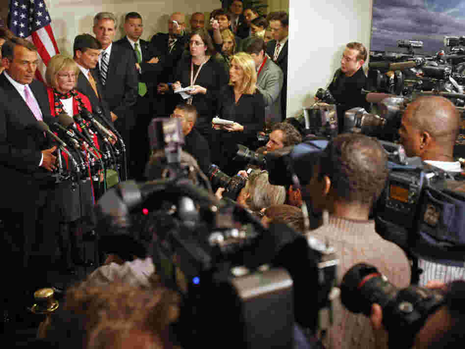 Surrounded by news media, House Speaker John Boehner announces a deal was reached, avoiding a government shutdown.