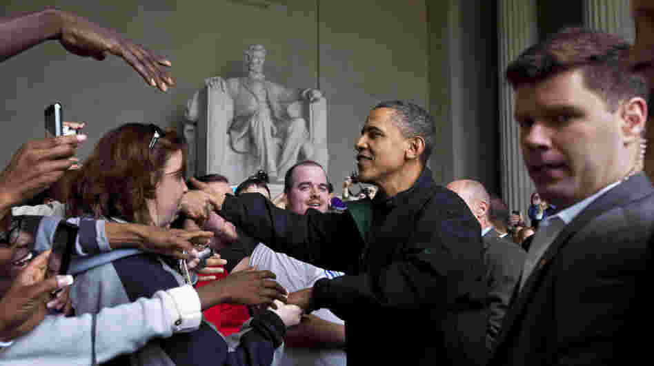 Barack Obama shakes hands with tourists visiting the Lincoln Memorial in Washington, D.C., Saturday during a surprise visit a day after budget negotiations with Congress prevented a government shutdown.