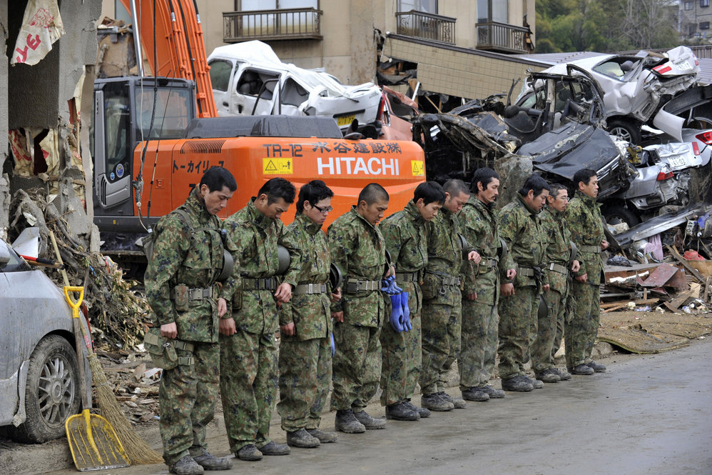 Members of the Japanese military offer a silent prayer for the dead in Kesennuma, Miyagi prefecture. 