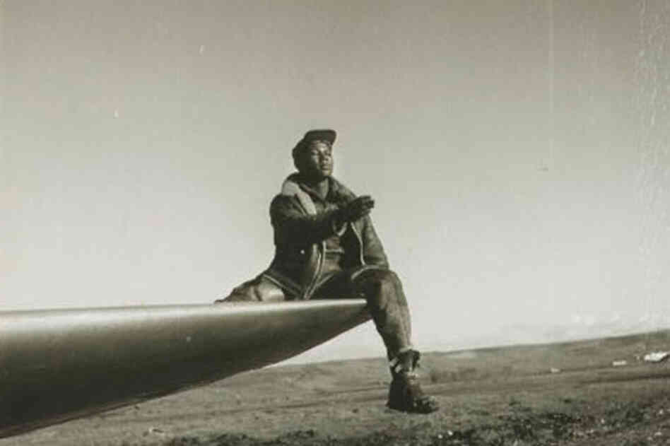 A ground crewman of the 332nd Fighter Group sits on a wing as he directs a pilot in Ramitelli. 