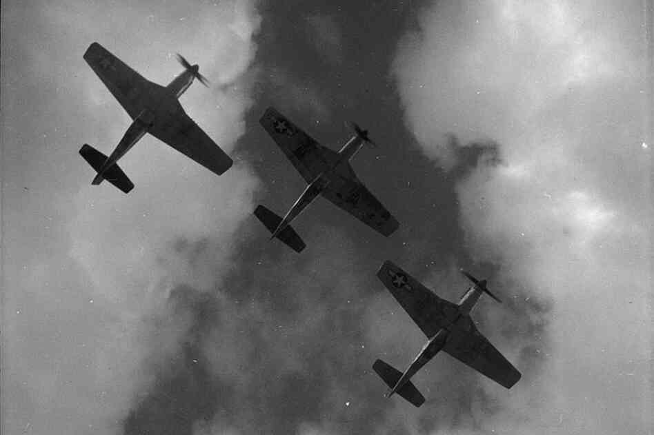 Three P-51 Mustangs fly in formation over Ramitelli, Italy, in March 1945. The Red Tails got their nickname from the distinctivebright red paint on the Mustangs' tails and noses. 