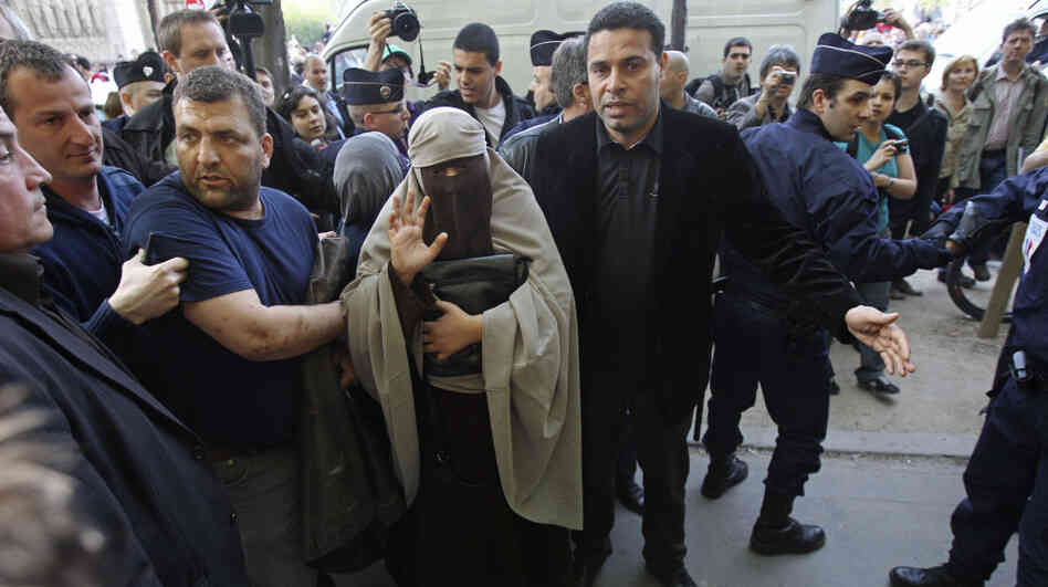 An unidentified veiled woman, flanked by friends, was taken away by police officers in Paris earlier today (April  11, 2011). France's new ban on Islamic face veils was met with a burst of defiance, as several women appeared veiled in front of Paris' Notre Dame Cathedral.