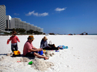 A family from New Orleans visits a beach in Pensacola, Fla., just before spring break season last month. In the distance, workers continue to clean up after the Deepwater Horizon oil spill. A family from New Orleans visits a beach in Pensacola, Fla., just before spring break season last month. In the distance, workers continue to clean up after the Deepwater Horizon oil spill.