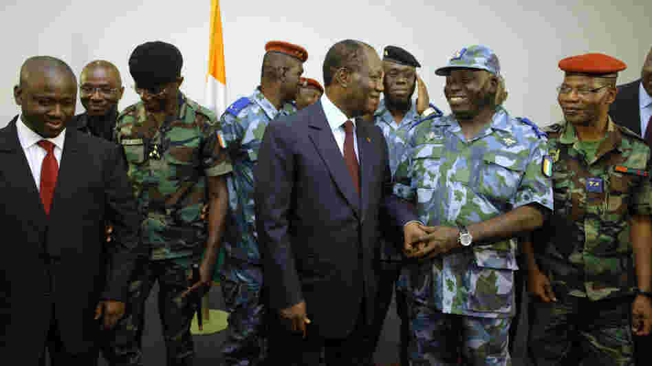 Ivory Coast's President Alassane Ouattara chats with military and police officials who've now pledged their support to him.
