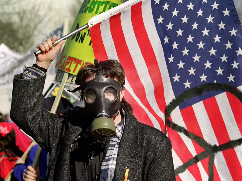 A demonstrator waves a flag marked with the peace symbol on Jan. 26, 1991, during an anti-Gulf War rally at the U.S. Capitol in Washington, D.C.