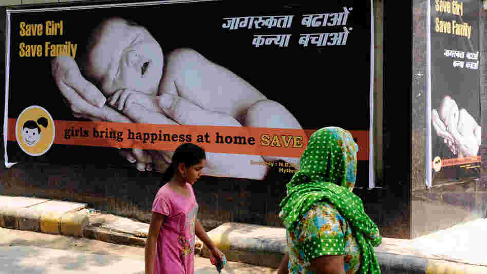 A woman and child walk past a billboard that promotes having girls last July. In India, there are far fewer girls born each year than boys. Some families use ultrasound technology to determine the gender of fetuses and then abort the females. A woman and child walk past a billboard that promotes having girls last July. In India, there are far fewer girls born each year than boys. Some families use ultrasound technology to determine the gender of fetuses and then abort the females.