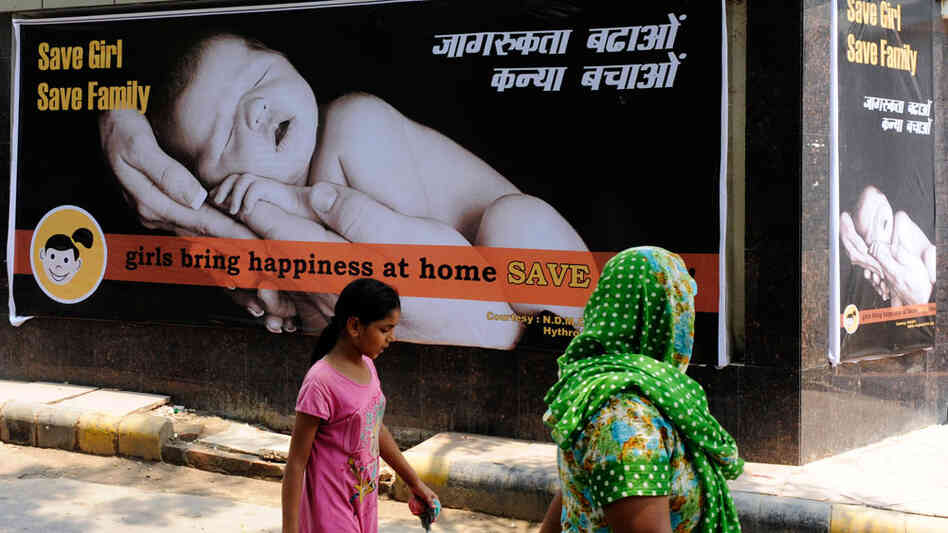 A woman and child walk past a billboard that promotes having girls last July. In India, there are far fewer girls born each year than boys. Some families use ultrasound technology to determine the gender of fetuses and then abort the females. A woman and child walk past a billboard that promotes having girls last July. In India, there are far fewer girls born each year than boys. Some families use ultrasound technology to determine the gender of fetuses and then abort the females.
