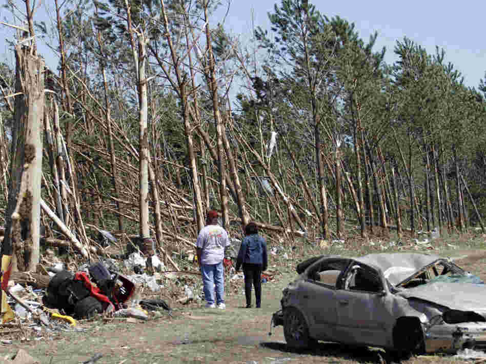 Passers-by inspect tornado damage Sunday in Askewville, N.C. Rescue crews searched for survivors in wind-blasted landscapes throughout the day Sunday and into Monday in North Carolina, the state hardest hit by a storm system that spawned dozens of tornadoes from Oklahoma to Virginia.