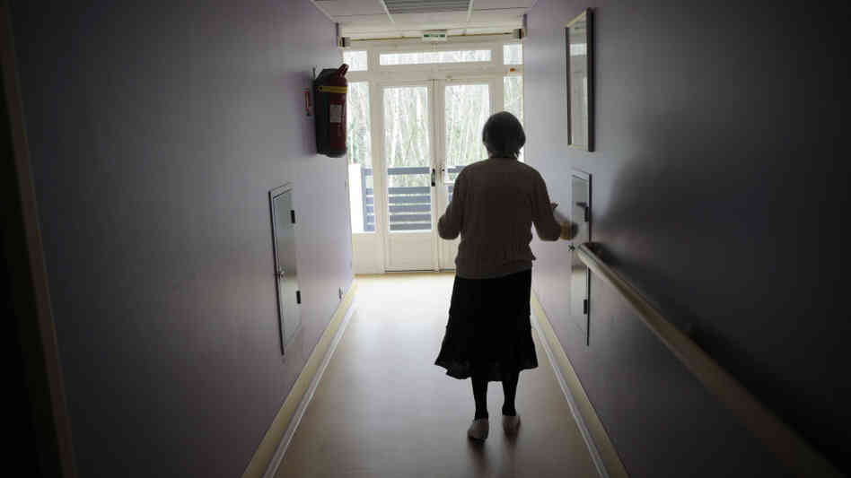 A woman with Alzheimer's disease walks in a corridor at a retirement house in Angervilliers, France, last month.