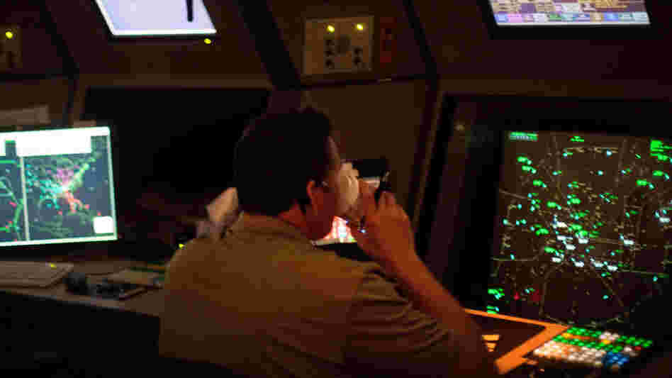 An air traffic controller drinks a cup of coffee while working in a terminal radar approach control room Monday at the Atlanta TRACON in Peachtree City, Ga. Several recent reports of controllers nodding off on the job prompted new scheduling rules.