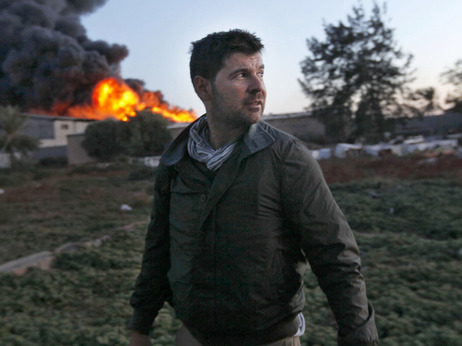 Getty Images photographer Chris Hondros stands in front of a burning building while on assignment on April 18, in Misrata, Libya. Hondros was killed in Misrata on April 20.