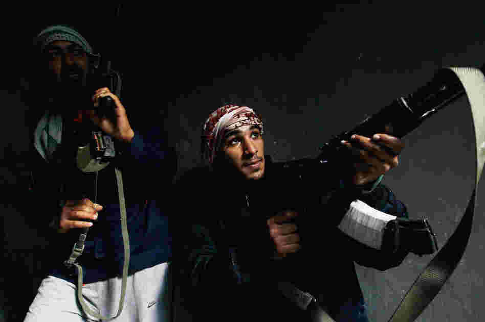 Rebel fighters carefully move into a building where they had trapped government loyalist troops during street fighting on Tripoli Street in downtown Misrata, Libya, on April 20. Photojournalist Chris Hondros was killed by a mortar round the day this photo was taken.