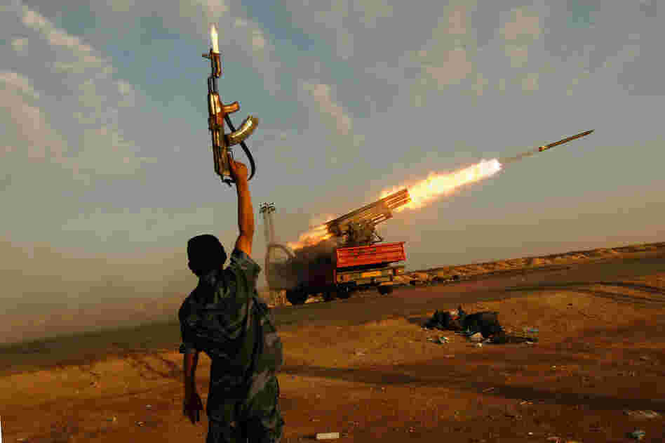 A rebel fighter celebrates as his comrades fire a rocket barrage toward the positions of troops loyal to Libyan ruler Moammar Gaddafi, April 14, west of Ajdabiyah.