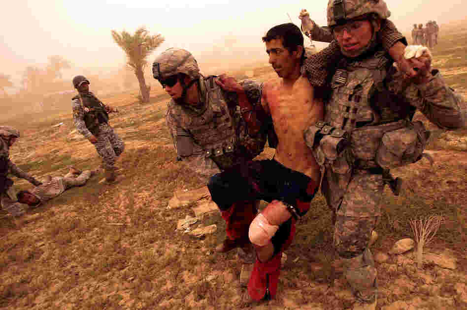 Medic Sgt. Matthew Kunkle (left) and Pvt. Aaron Livas carry a wounded Iraqi man in Baghdad on May 16, 2008. The man had been shot in the leg by U.S. troops after trying to flee from them. He was immediately treated by the U.S. medic traveling with the platoon and transported to the nearest base for medical care.