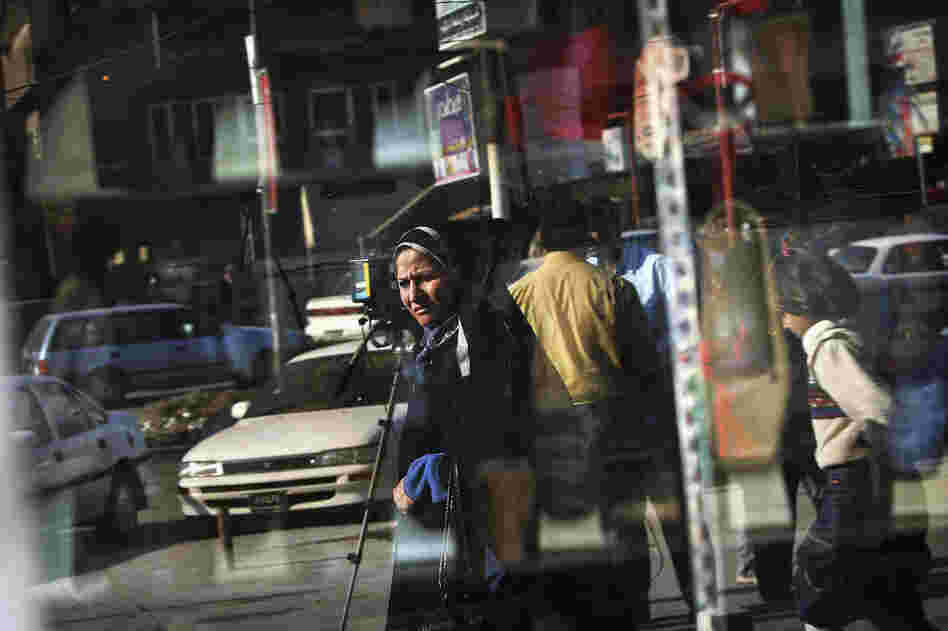 A woman is reflected in a Baghdad shop window on a busy boulevard, Feb. 3, 2005.