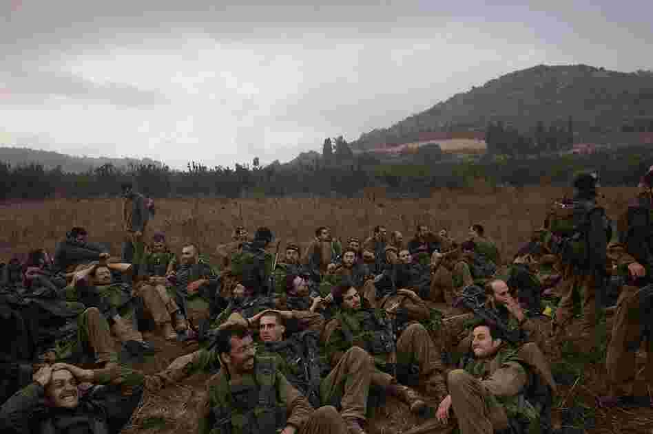Exhausted Israeli soldiers gather on the Israeli-Lebanese border after marching in from Lebanon the morning of Aug. 14.