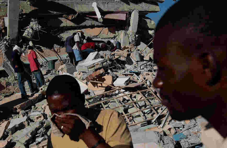 Haitians pass in front of the collapsed multistory St. Gerard School in Port-au-Prince on Jan.15, 2010.