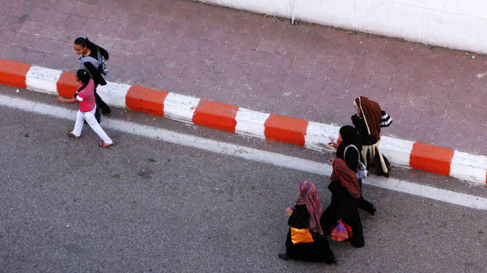 Christian and Muslim girls walk on the street in Qena, Egypt. Residents worry growing religious strife could tear the city apart. Christian and Muslim girls walk on the street in Qena, Egypt. Residents worry growing religious strife could tear the city apart.