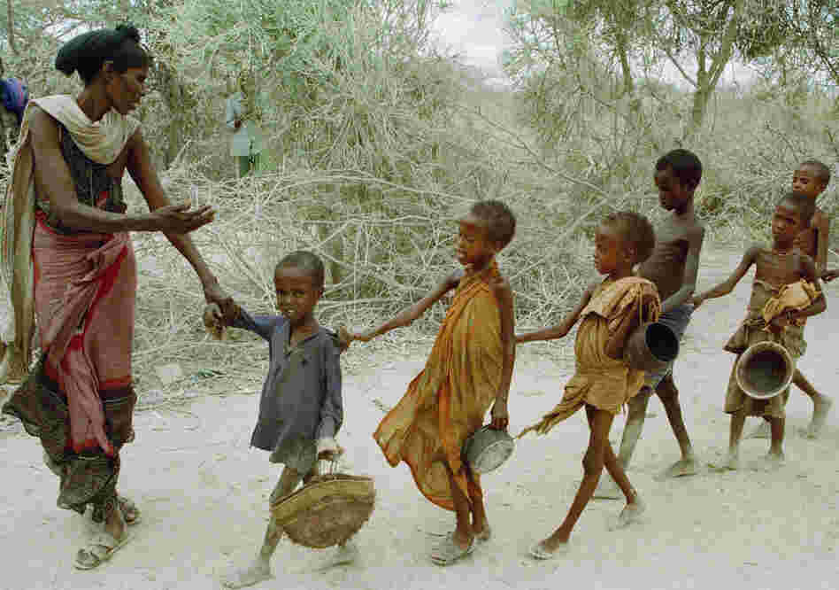 In 1992, Marinovich traveled to Somalia to document the war and famine. In this photo, a woman leads children — who had been waiting all day to be fed — to a food kitchen. 