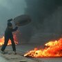 In the late 1990s, both Marinovich and Silva traveled to the Middle East to photograph the ongoing clashes in the region. Silva captured this image of a young Palestinian boy throwing a tire in the West Bank town of A-Ram in March 1997. In the late 1990s, both Marinovich and Silva traveled to the Middle East to photograph the ongoing clashes in the region. Silva captured this image of a young Palestinian boy throwing a tire in the West Bank town of A-Ram in March 1997.
