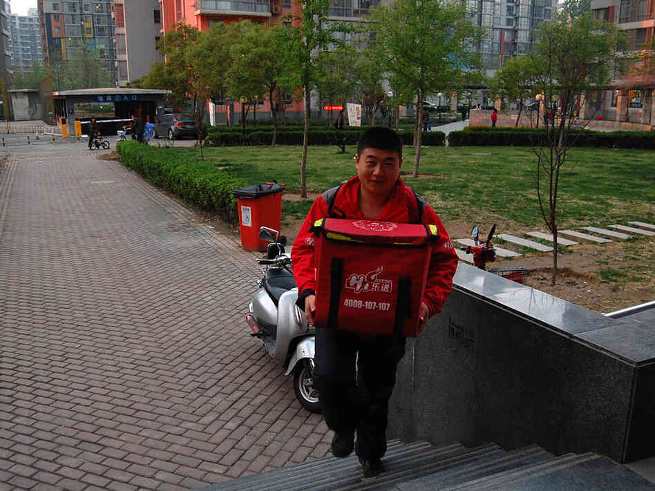 Haidilao delivery man Liu Lei rides an electric moped to a customer's house, with two backpacks — one with the food, one with the hot plate, pot and utensils. He arrives one hour after the order was placed. Haidilao delivery man Liu Lei rides an electric moped to a customer's house, with two backpacks — one with the food, one with the hot plate, pot and utensils. He arrives one hour after the order was placed.