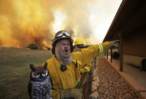 Firefighter Craig Howard yells to fire crews as they take up positions to save a house from the wildfire near Possum Kingdom, Texas, on Tuesday. Firefighter Craig Howard yells to fire crews as they take up positions to save a house from the wildfire near Possum Kingdom, Texas, on Tuesday.