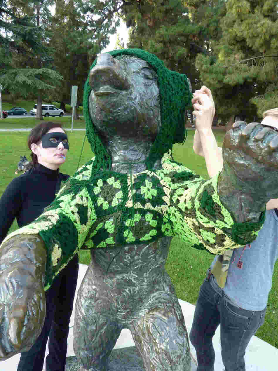 Captain Hook (left) and her accomplice, Vanessa XKiller, vandalize a bear statue in L.A.'s Griffith Park in the most cozy way possible: with a hand-crocheted hoodie. Stepping back to assess their handiwork, Vanessa concludes, it's "gangster cute."