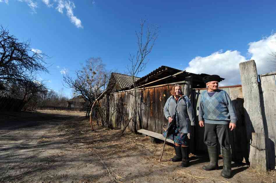 Ivan Semenyuk, 75, and his wife, Maria, 73, stand outside their house in the largely abandoned village of Paryshiv, inside the exclusion zone, in March 2011.  