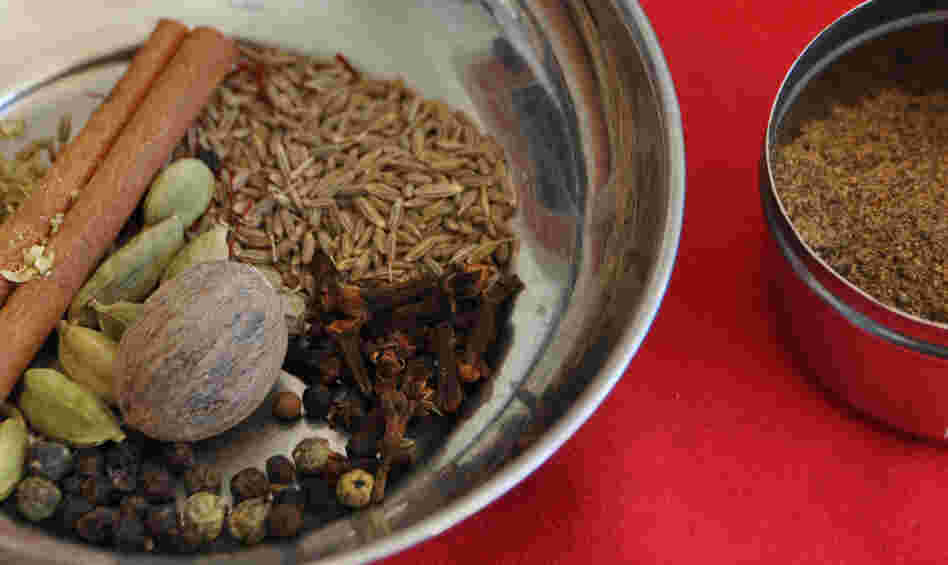 A bowl containing components of garam masala spice, and a bowl of the ground spices