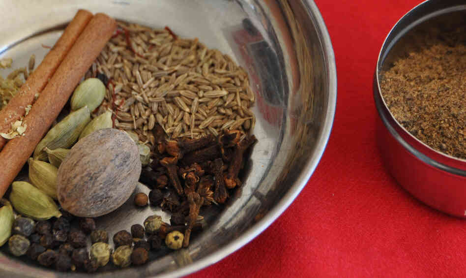 A bowl containing components of garam masala spice, and a bowl of the ground spices
