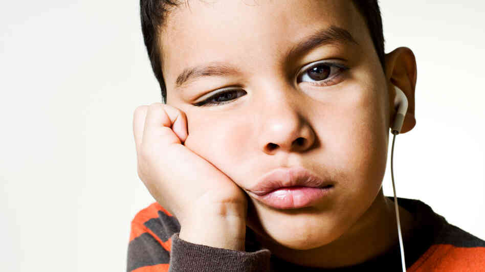Child bored out of his mind, listening to something. Child bored out of his mind, listening to something.